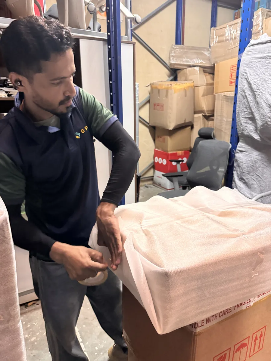 GPS Movers crew member taping foam wrap around furniture