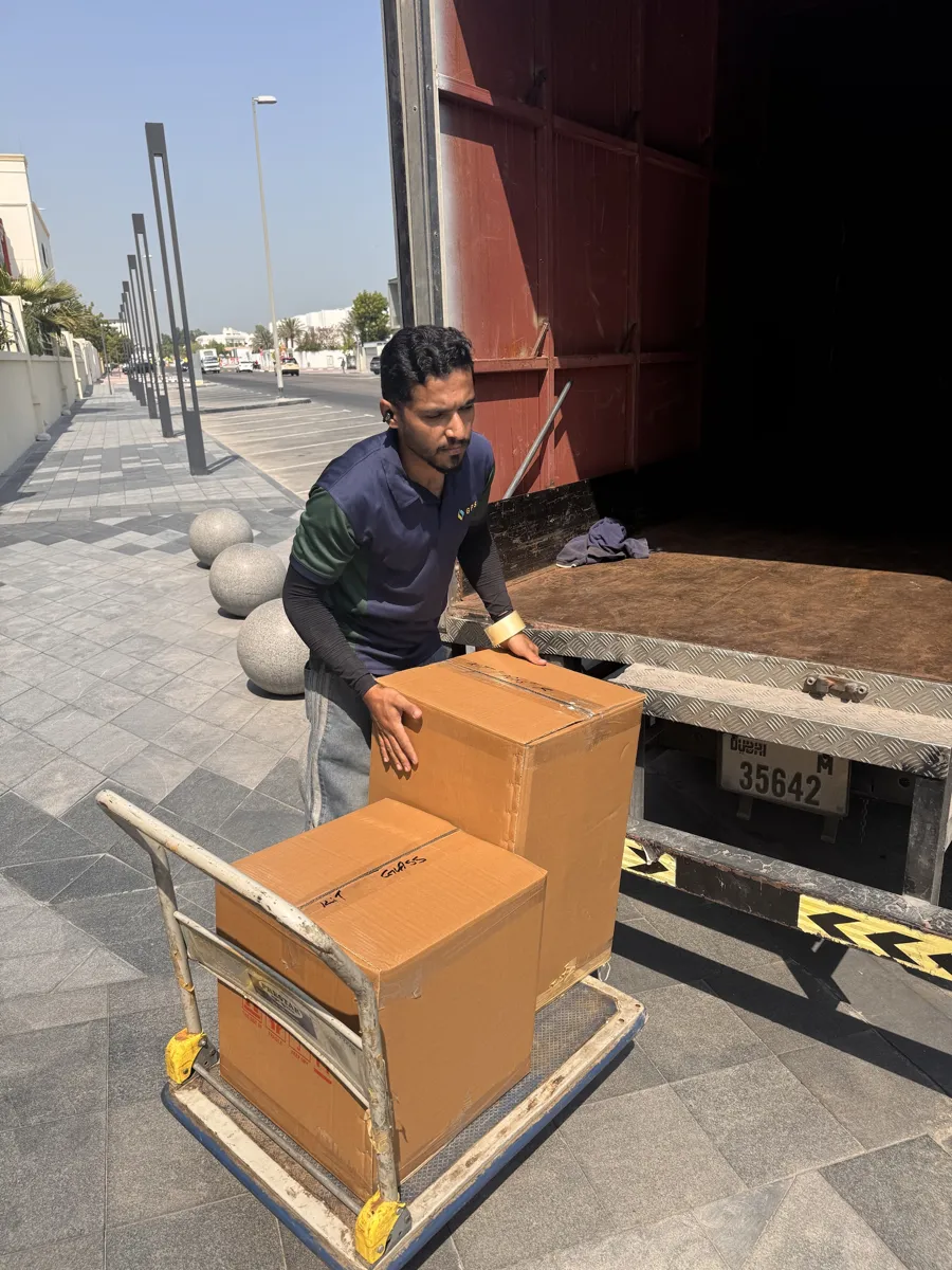 GPS Movers crew member moving labelled boxes on a trolley to the truck
